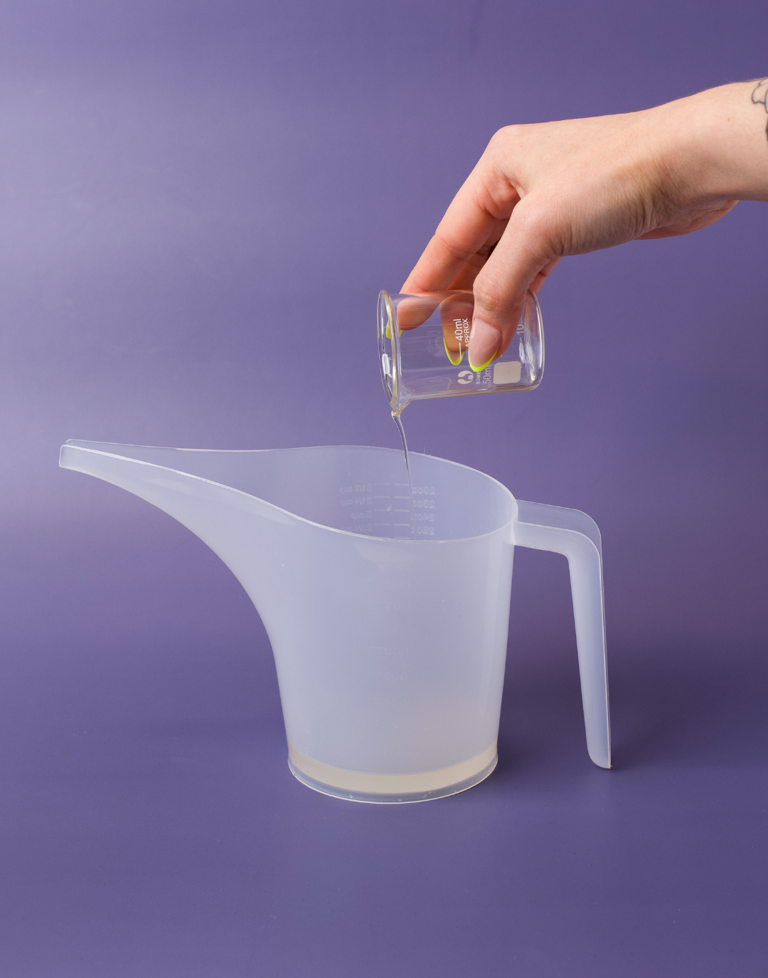 Pouring fragrance into pouring pitcher with base in it.